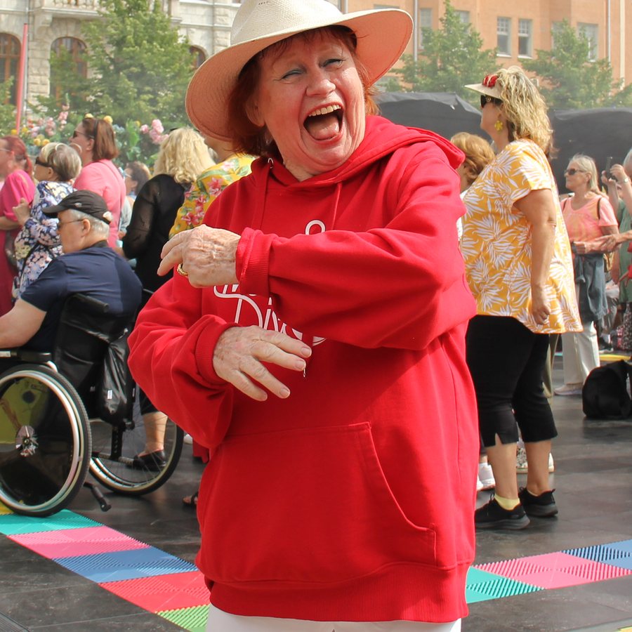 Tuija Piepponen punaisessa takissa tanssilattialla